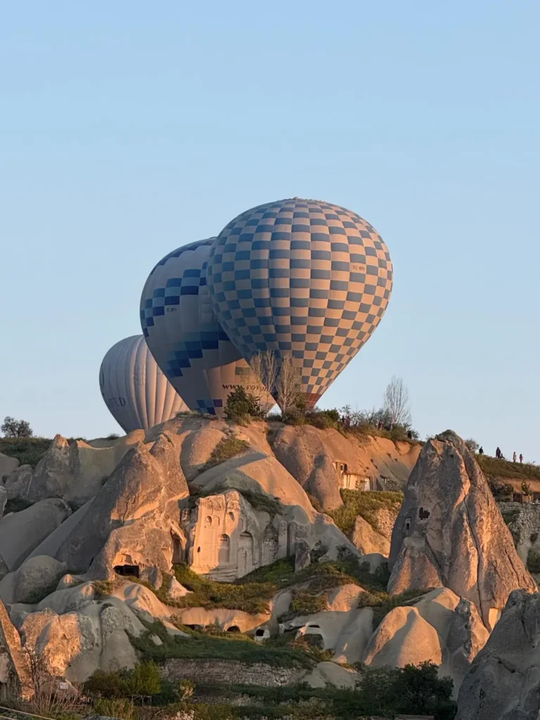 Hot air balloons rising over the rocky valleys of Cappadocia during a private history tour of Turkey